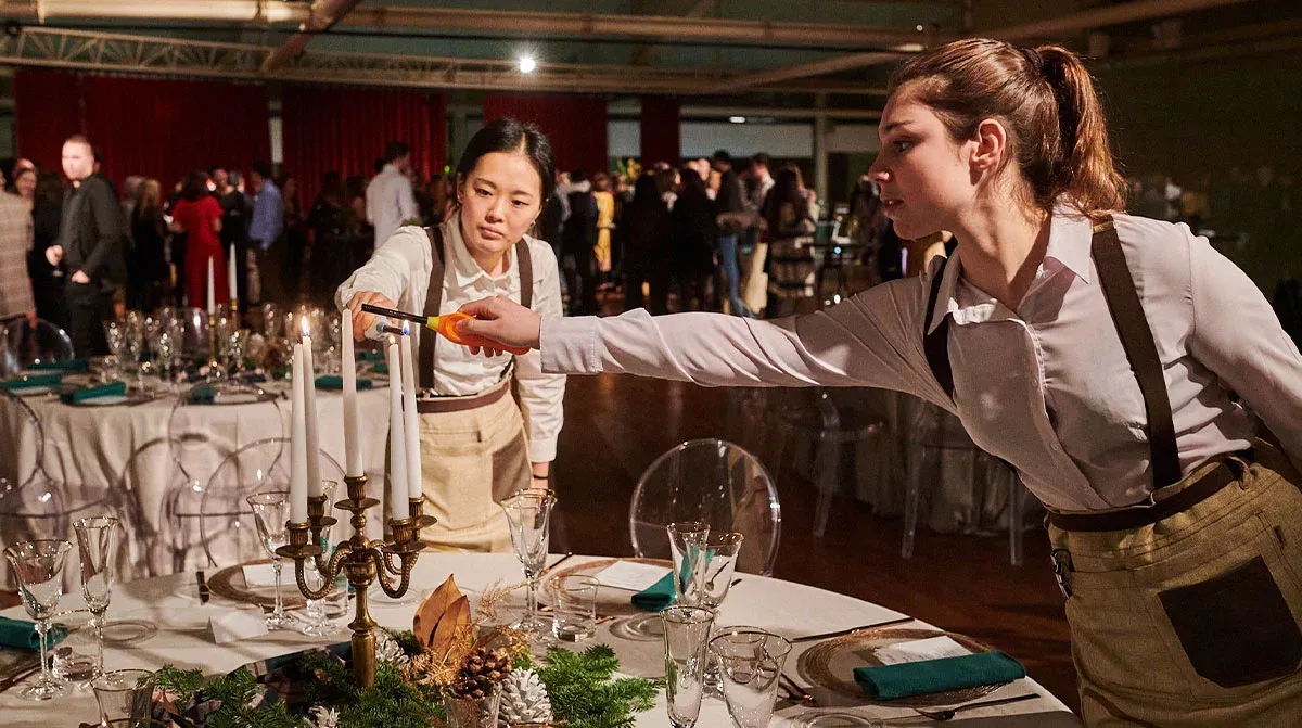 two waitresses lighting candles