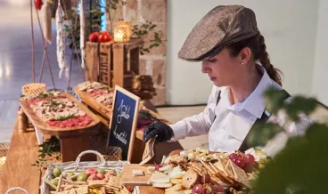 a woman preparing a cheese board