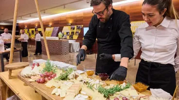 two chefs preparing a cheese board